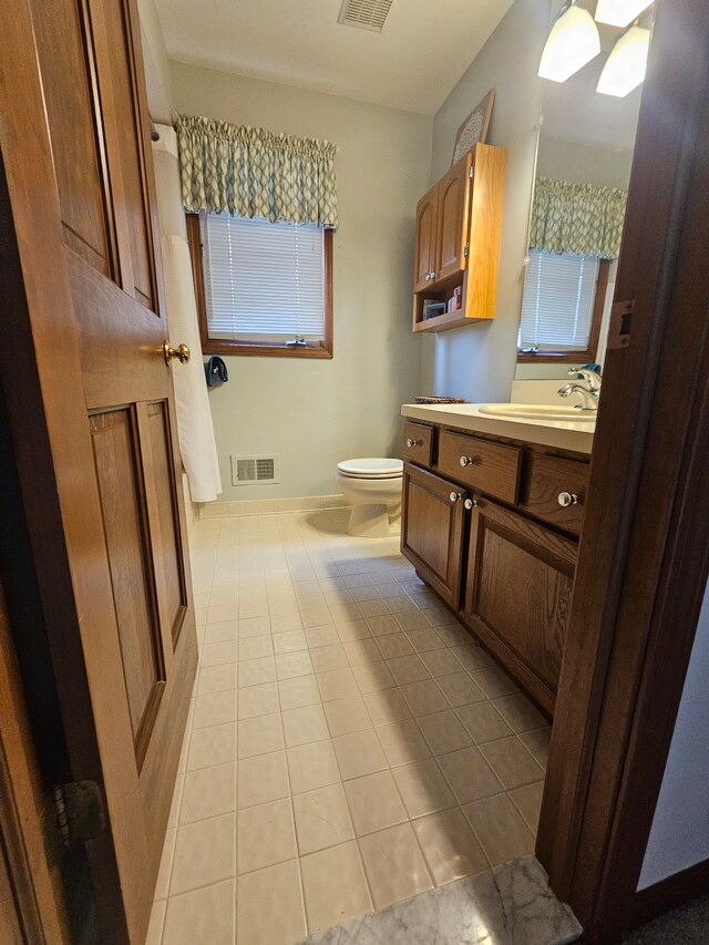 bathroom with toilet, tile patterned floors, vanity, and visible vents