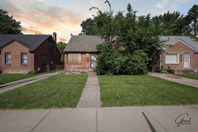 19401 Grandview St, Detroit, MI 48219 - view of front facade featuring brick siding, a chimney, a front lawn, and a shingled roof