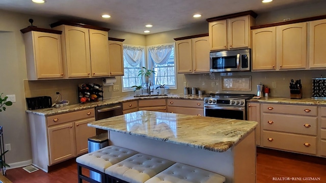 5393 Blaine Ave SE, Grand Rapids, MI 49508 - kitchen featuring light stone counters, backsplash, appliances with stainless steel finishes, and a sink