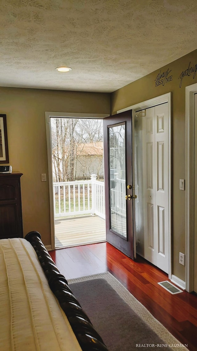 5393 Blaine Ave SE, Grand Rapids, MI 49508 - interior space with wood finished floors, visible vents, baseboards, access to exterior, and a textured ceiling