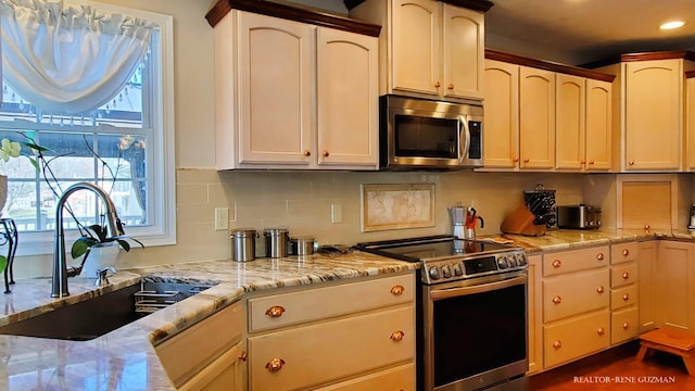 5393 Blaine Ave SE, Grand Rapids, MI 49508 - kitchen featuring light stone counters, recessed lighting, a sink, stainless steel appliances, and tasteful backsplash