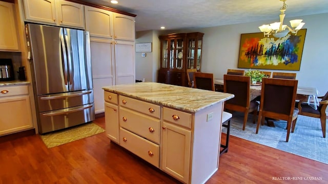 5393 Blaine Ave SE, Grand Rapids, MI 49508 - kitchen with a kitchen island, a notable chandelier, dark wood-style flooring, and freestanding refrigerator
