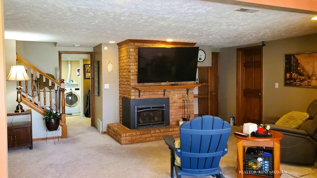 5393 Blaine Ave SE, Grand Rapids, MI 49508 - living room with visible vents, a textured ceiling, a fireplace, carpet flooring, and washer / dryer
