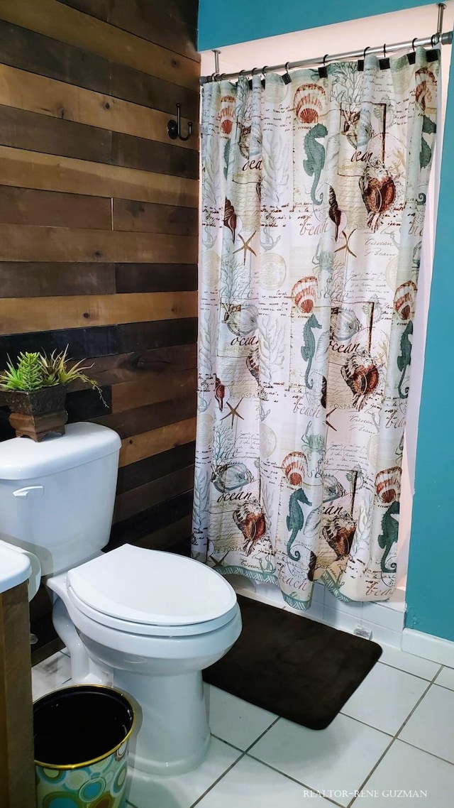 5393 Blaine Ave SE, Grand Rapids, MI 49508 - bathroom with tile patterned floors, wooden walls, toilet, and a shower with curtain