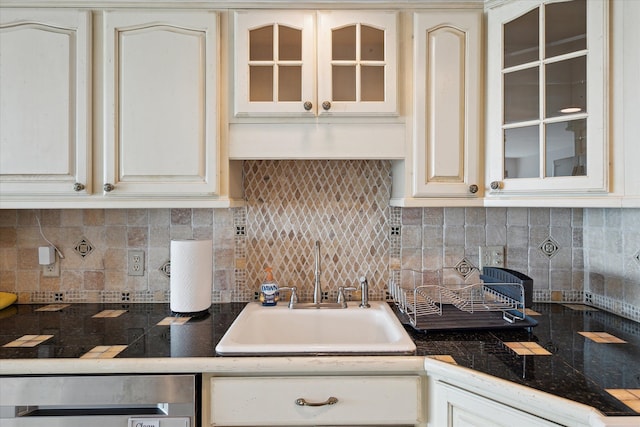 555 E William St, Ann Arbor, MI 48104 - kitchen featuring a sink, dishwasher, backsplash, glass insert cabinets, and cream cabinets