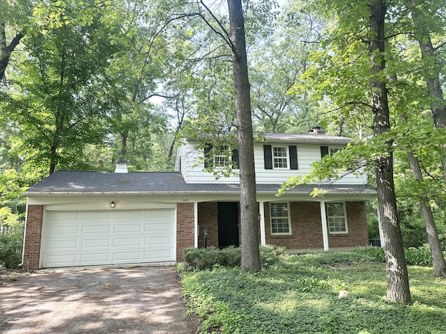 7325 Sheffield Dr SE, Ada, MI 49301 - traditional home with driveway, brick siding, an attached garage, and a chimney