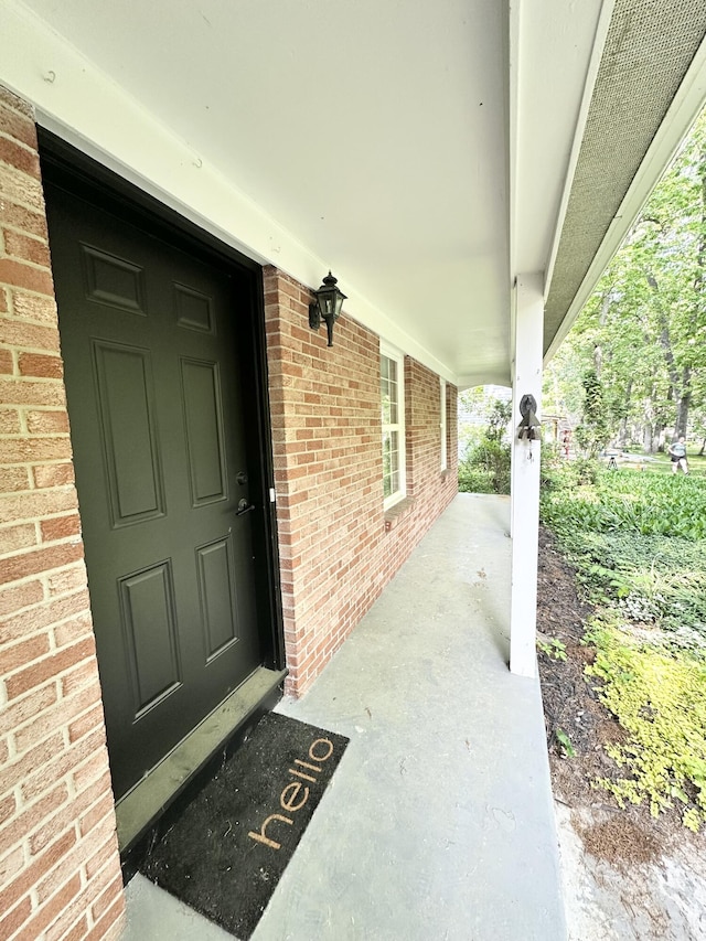 7325 Sheffield Dr SE, Ada, MI 49301 - view of exterior entry featuring a porch and brick siding