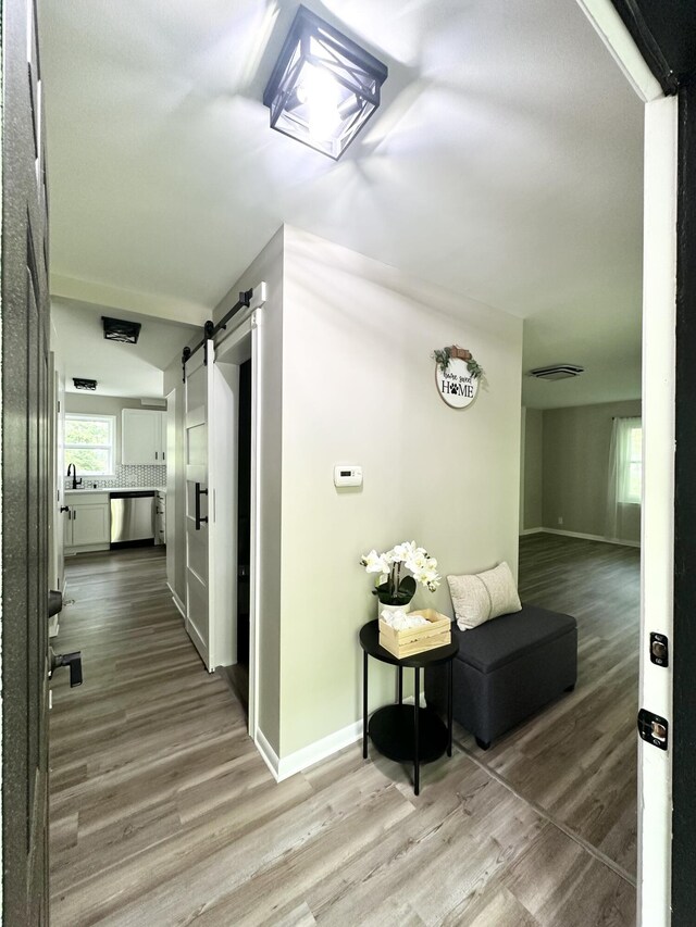 7325 Sheffield Dr SE, Ada, MI 49301 - corridor featuring a barn door, wood finished floors, and lofted ceiling