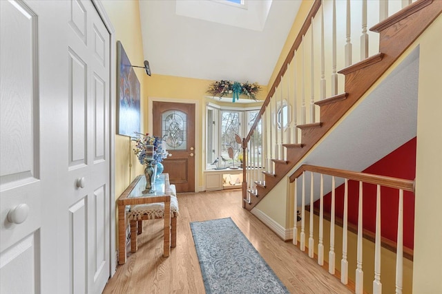 9283 Firwood Rd, South Lyon, MI 48178 - foyer entrance featuring baseboards, a skylight, stairway, and wood finished floors