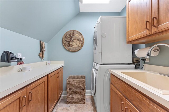 9283 Firwood Rd, South Lyon, MI 48178 - laundry area featuring a sink, cabinet space, stacked washer / drying machine, and baseboards