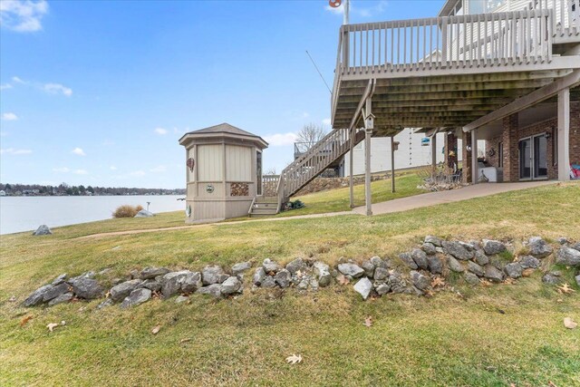 9283 Firwood Rd, South Lyon, MI 48178 - view of yard featuring a deck with water view, stairway, and a patio area