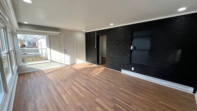 empty room with recessed lighting, crown molding, and wood finished floors