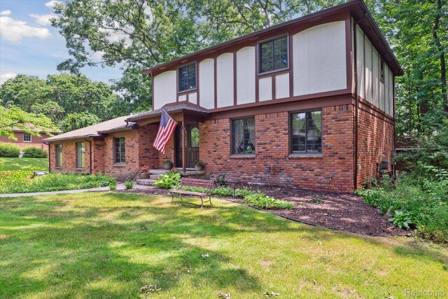 2915 Hillendale Dr, Rochester Hills, MI 48309 - english style home featuring brick siding, a front yard, and board and batten siding