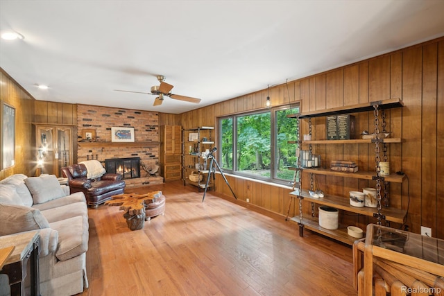 2915 Hillendale Dr, Rochester Hills, MI 48309 - living room with wooden walls, wood finished floors, a fireplace, and a ceiling fan