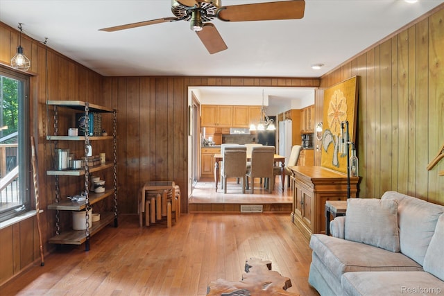 2915 Hillendale Dr, Rochester Hills, MI 48309 - living area featuring wood walls, a ceiling fan, light wood-style floors, and a chandelier