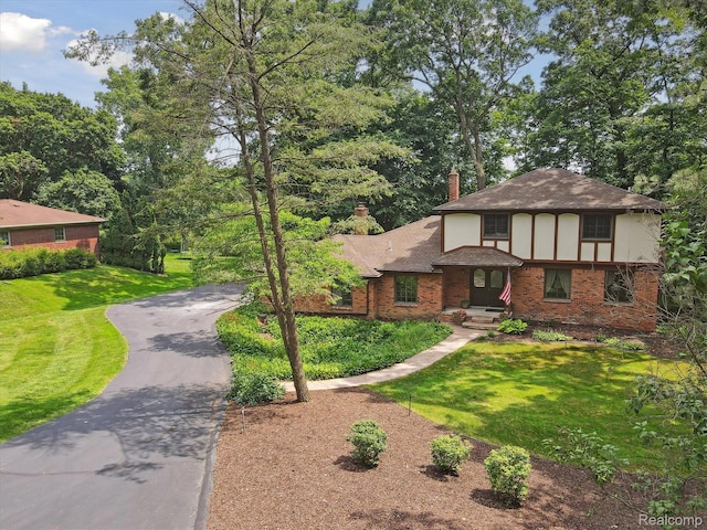 2915 Hillendale Dr, Rochester Hills, MI 48309 - english style home with brick siding, a chimney, driveway, roof with shingles, and a front yard