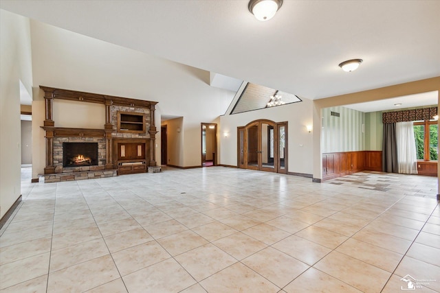 8650 Stone Rd, Maybee, MI 48159 - unfurnished living room with a fireplace, light tile patterned flooring, and wainscoting