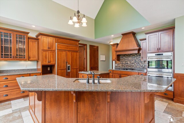 8650 Stone Rd, Maybee, MI 48159 - kitchen featuring paneled built in refrigerator, custom range hood, a large island with sink, recessed lighting, and brown cabinets
