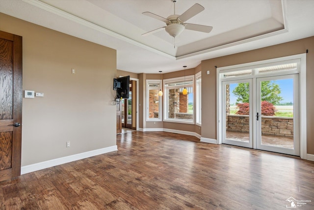 8650 Stone Rd, Maybee, MI 48159 - unfurnished living room featuring a tray ceiling, wood finished floors, a ceiling fan, and french doors