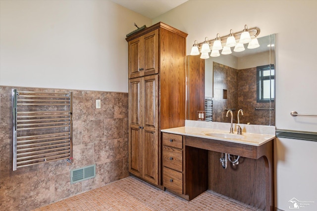 8650 Stone Rd, Maybee, MI 48159 - full bathroom featuring radiator heating unit, vanity, a towel warmer, and tile walls