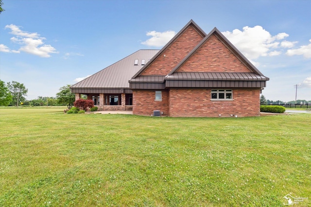 8650 Stone Rd, Maybee, MI 48159 - view of home's exterior featuring a standing seam roof, a metal roof, a lawn, and brick siding