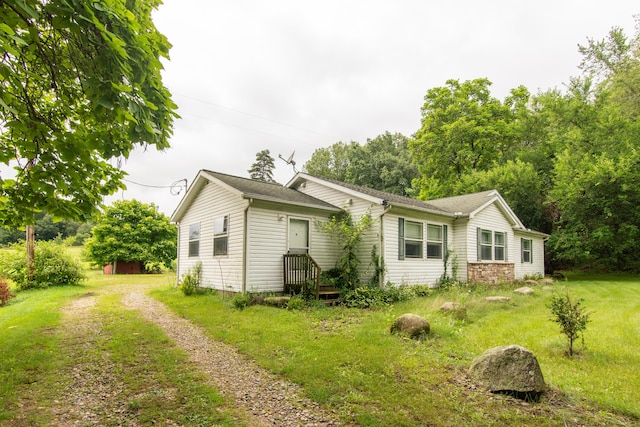 exterior space with a lawn and dirt driveway