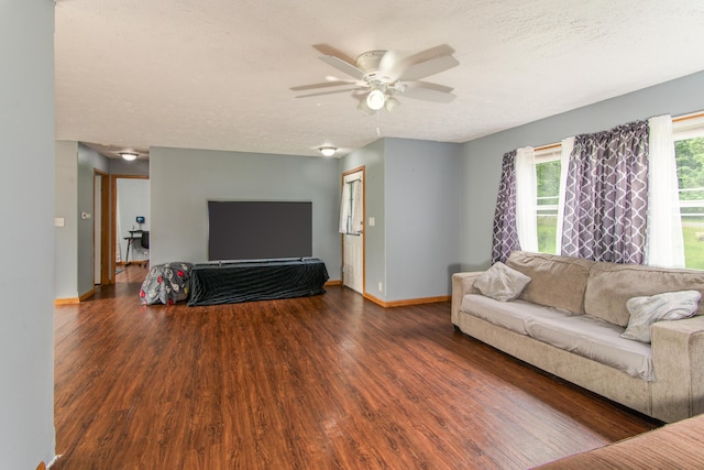 living area with baseboards, a textured ceiling, a ceiling fan, and wood finished floors
