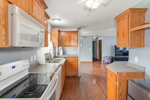 kitchen featuring a sink, white appliances, a ceiling fan, and light countertops