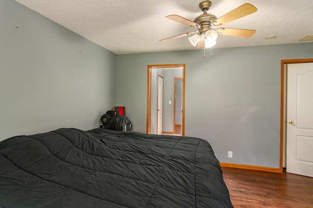bedroom featuring baseboards, a textured ceiling, wood finished floors, and a ceiling fan