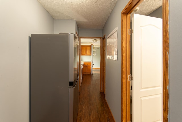corridor featuring dark wood finished floors and a textured ceiling