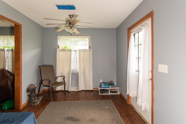 living area with baseboards, ceiling fan, and wood finished floors