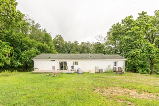 rear view of house featuring a deck, cooling unit, and a lawn
