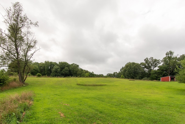 view of yard with a rural view and an outdoor structure