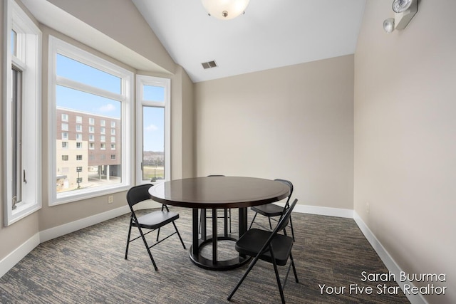 dining room with baseboards, vaulted ceiling, and visible vents