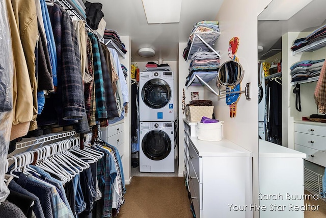 washroom with carpet flooring, stacked washer / dryer, and laundry area