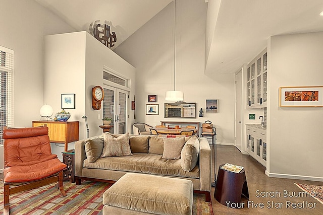 living area with high vaulted ceiling and baseboards