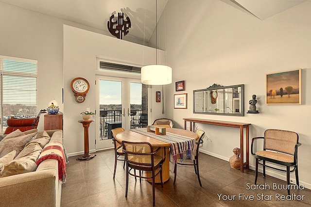 dining area with plenty of natural light, baseboards, a high ceiling, and french doors