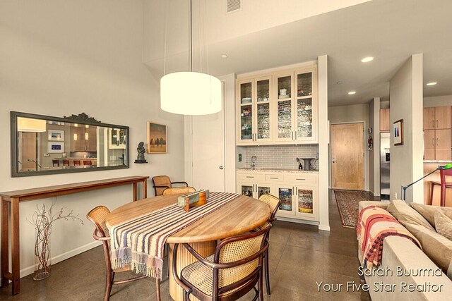 dining space featuring baseboards, visible vents, indoor wet bar, and recessed lighting