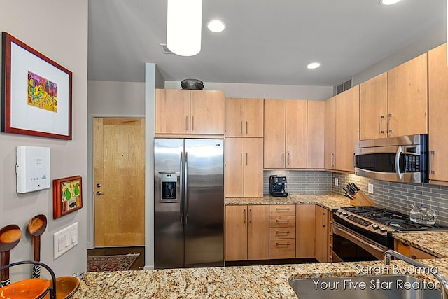 kitchen with recessed lighting, backsplash, light stone counters, visible vents, and appliances with stainless steel finishes