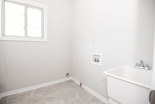 laundry room with laundry area, washer hookup, baseboards, and a sink