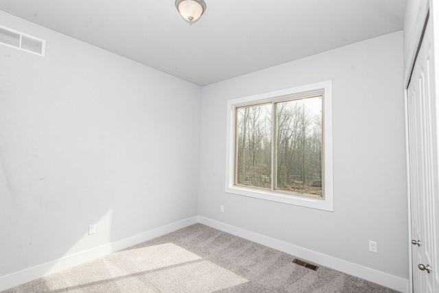 unfurnished room with visible vents, carpet floors, and baseboards