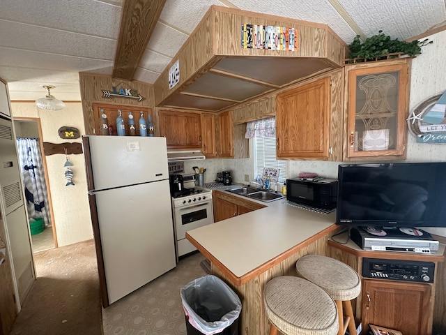 kitchen with white appliances, ventilation hood, a peninsula, a sink, and brown cabinets