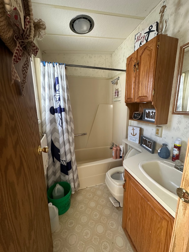 full bath featuring vanity, wallpapered walls, shower / bath combo, a textured ceiling, and toilet