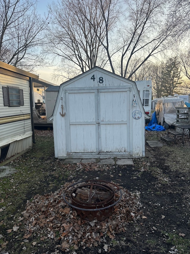 view of shed with an outdoor fire pit
