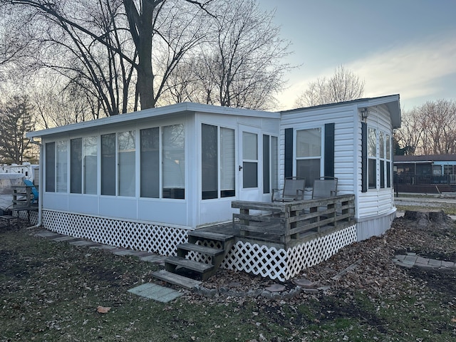 view of front of property featuring a sunroom and a wooden deck