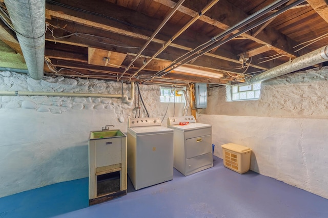 below grade area with washer and clothes dryer, electric panel, healthy amount of natural light, and a sink