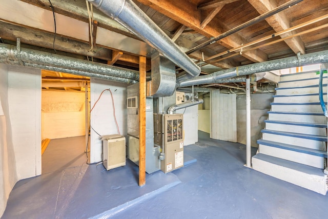 unfinished basement featuring stairway and heating unit