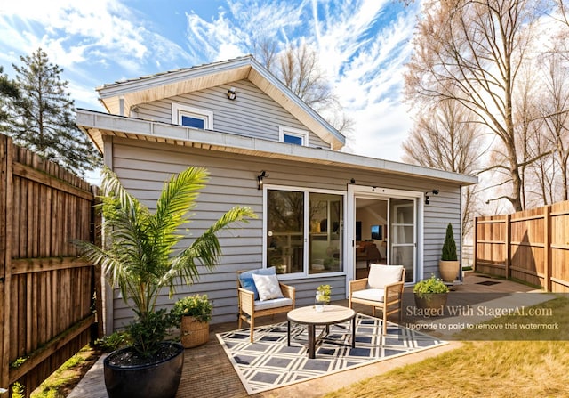 rear view of property featuring fence and a patio