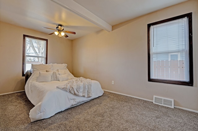 bedroom featuring baseboards, carpet floors, beamed ceiling, visible vents, and a ceiling fan
