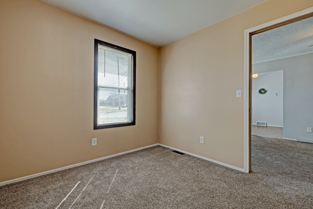 carpeted empty room with baseboards and visible vents